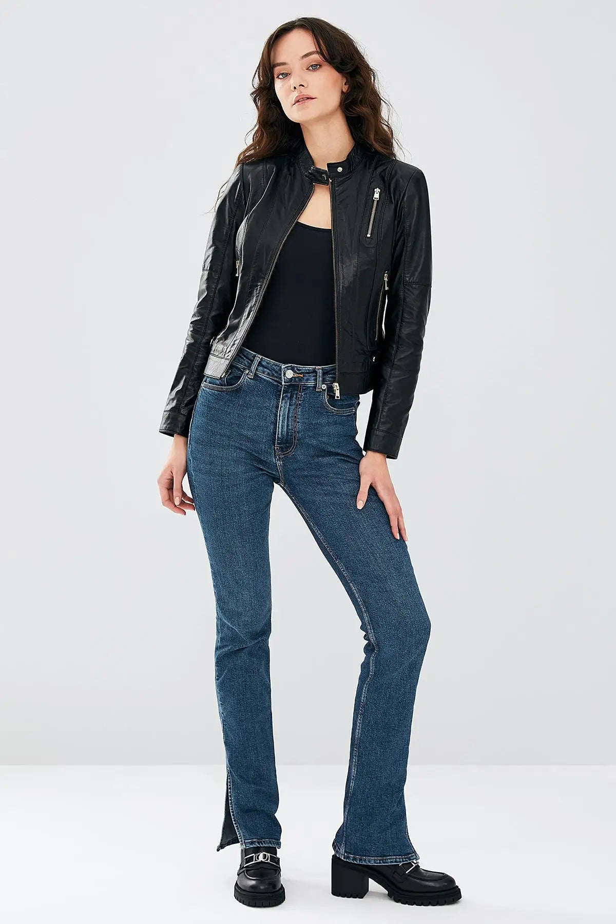 Woman wearing black stretch-fit leather biker jacket with jeans, casual styling