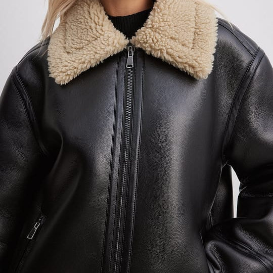 Close-up of genuine tan shearling collar, hide-to-fleece continuous construction, women's aviator jacket