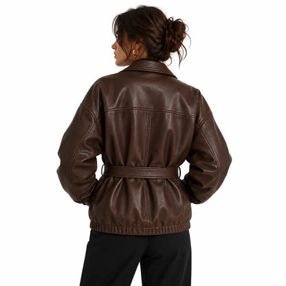 Woman wearing oversized brown leather jacket belted at the waist, styled with black turtleneck, back look