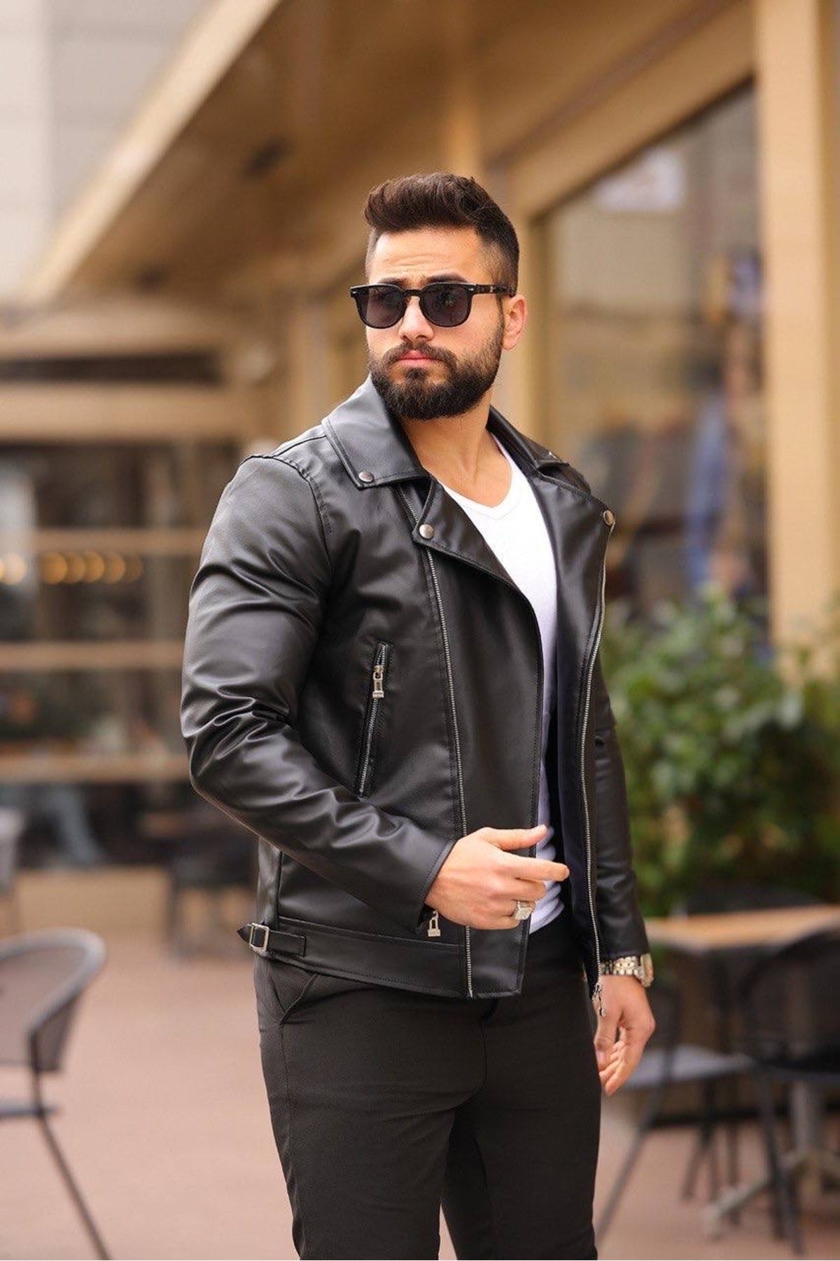 Front view of black leather biker jacket showing dual zip chest pockets and lapel snaps