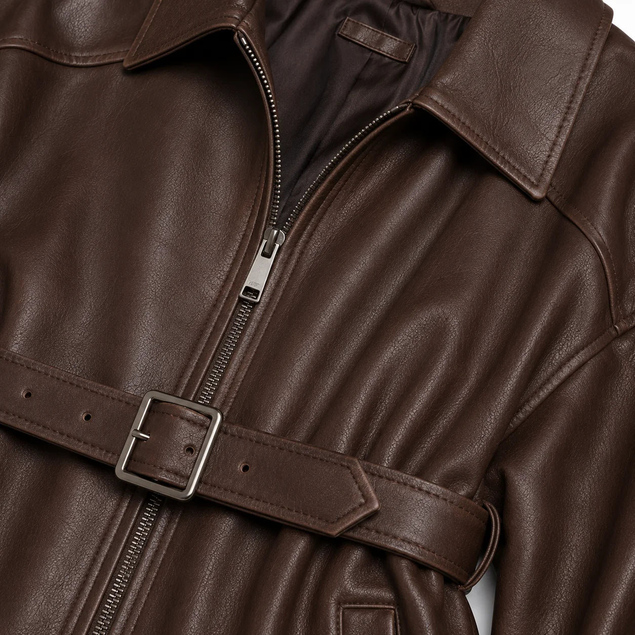 Close-up of matte chocolate lambskin grain and belted waist detail, women's brown leather jacket