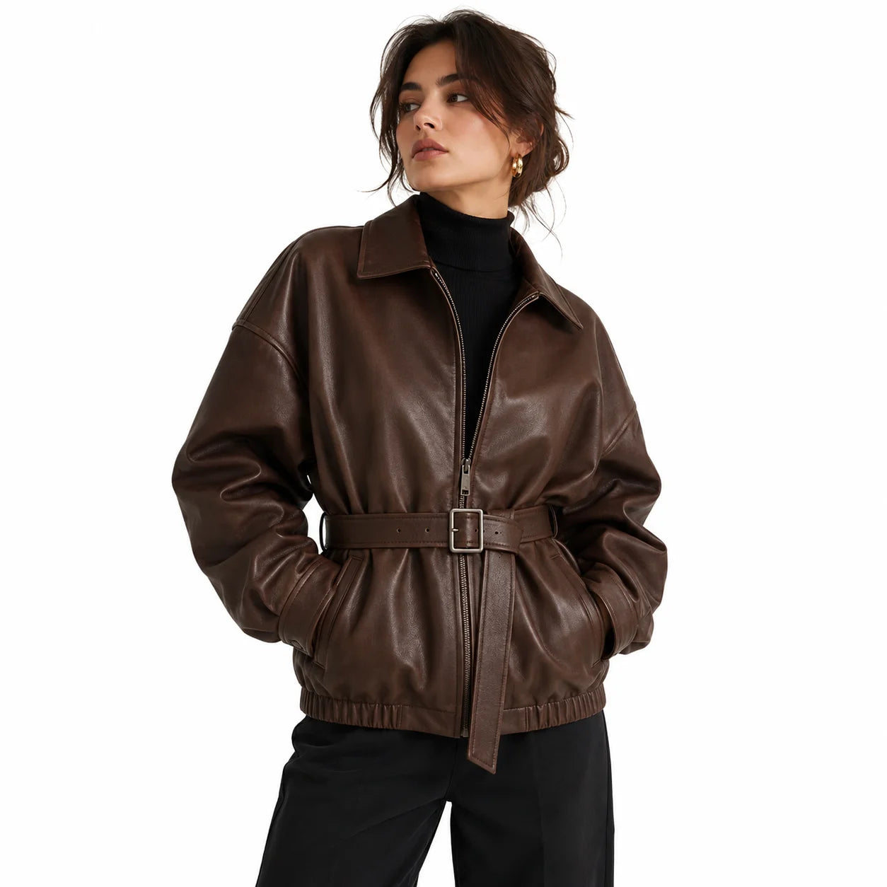 Woman wearing oversized brown leather jacket belted at the waist, styled with black turtleneck
