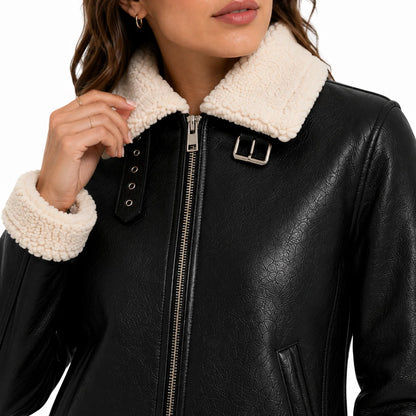 Close-up of ivory faux shearling collar and buckle detail on black vegan leather jacket